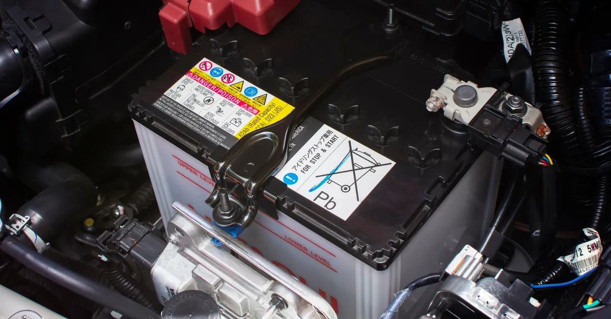 A car battery inside a car engine compartment.