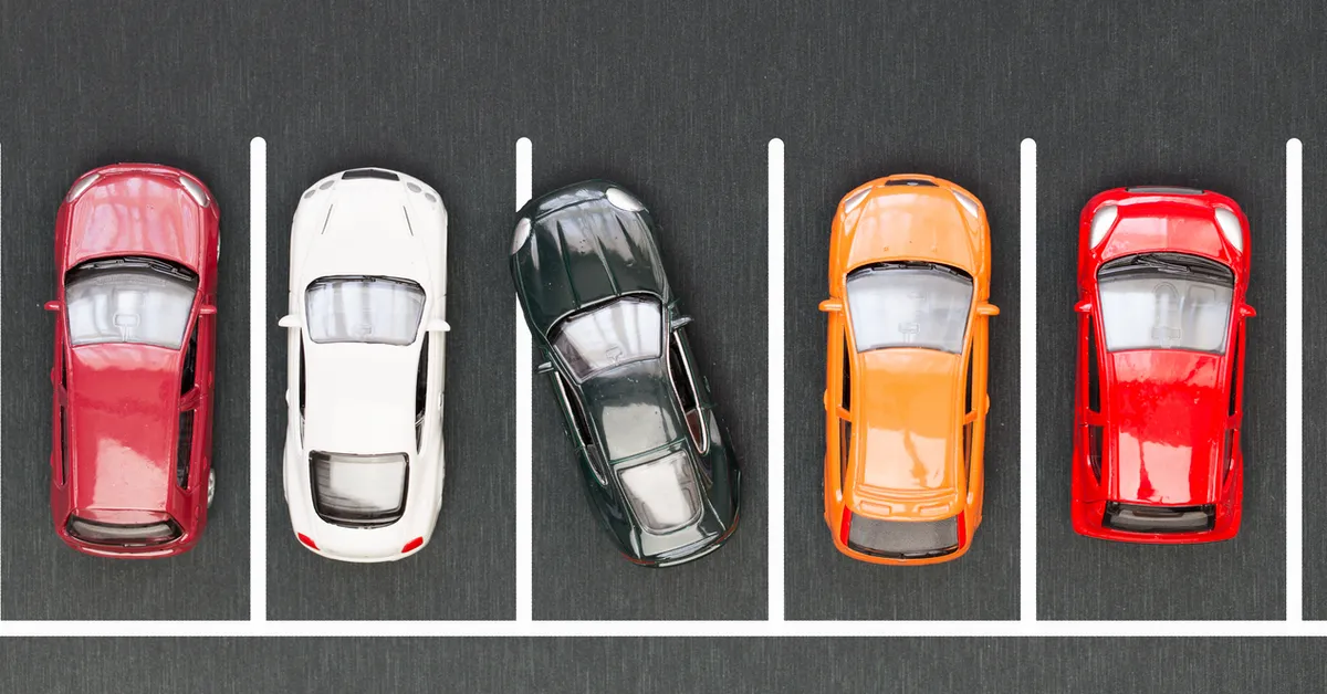 An overhead shot of cars lined up in a car park. The middle car is angled in its space.