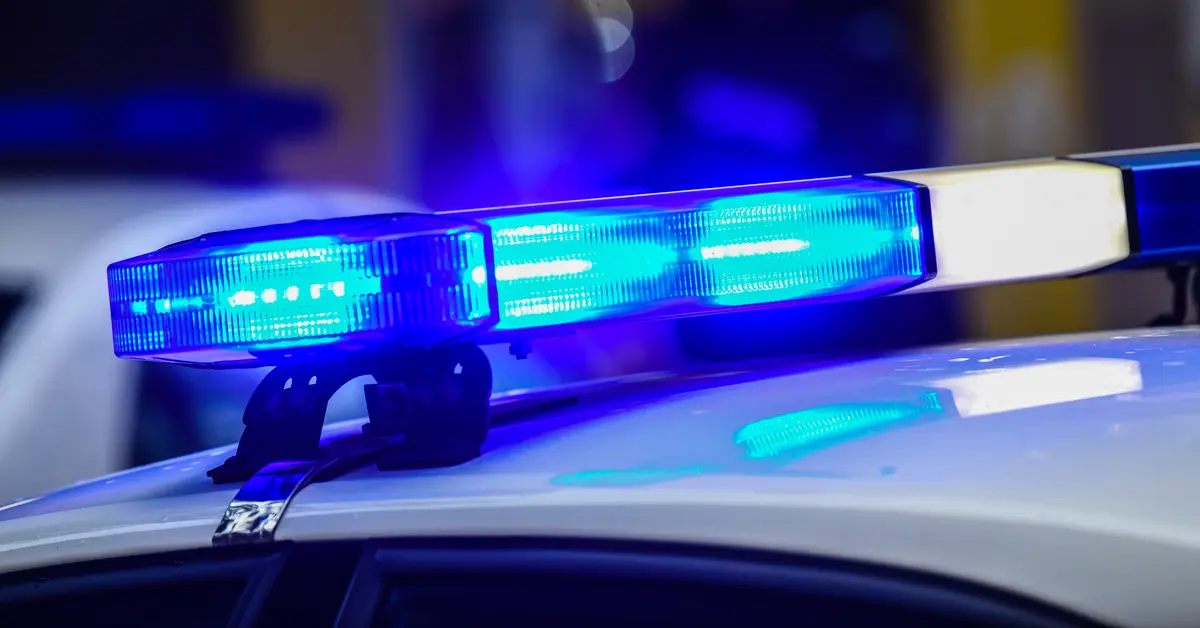 Close up of a police car with the lights flashing on the roof.
